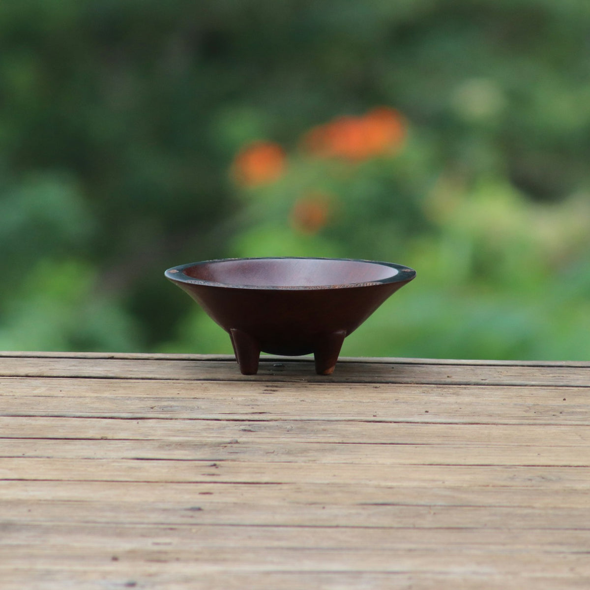 pkkavabowl A dark wooden kava bowl resting on a weathered table