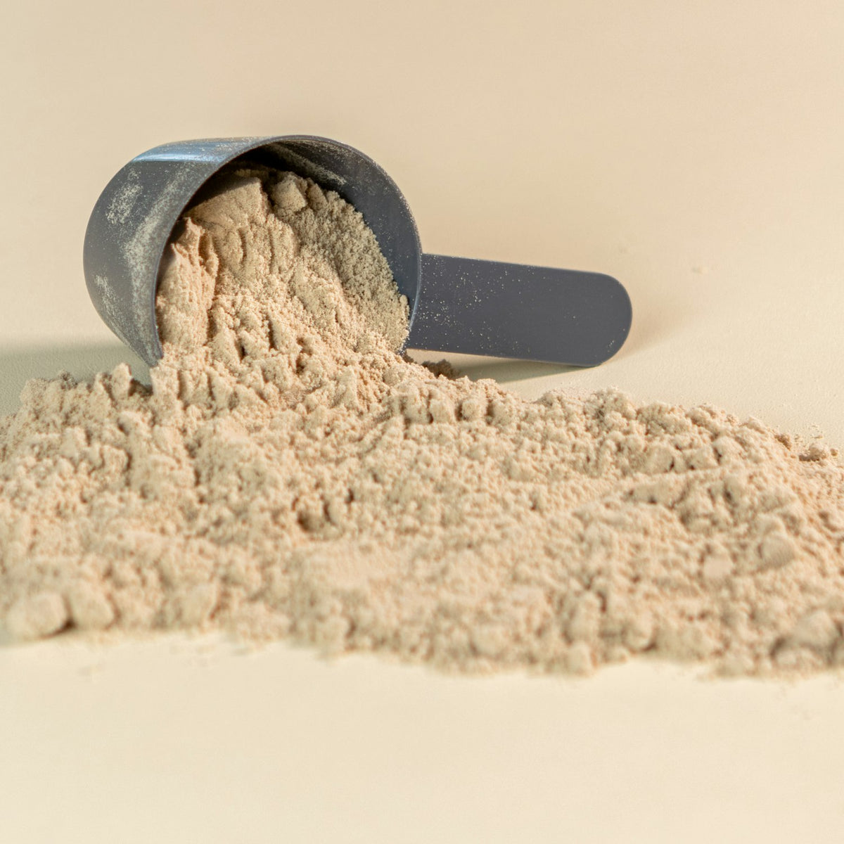 pkkavapowder Finely ground kava root powder beside a stone grinder